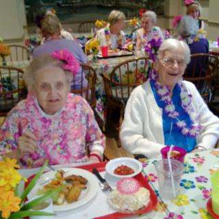 A joyful gathering of elderly women enjoying a meal at a festive party.