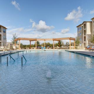 A serene view of an outdoor swimming pool surrounded by residential apartment buildings.