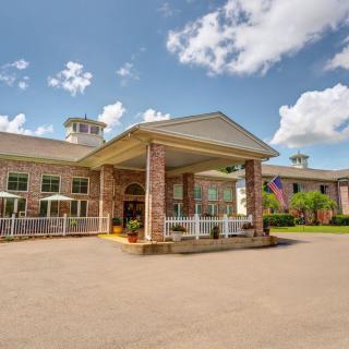 Exterior view of a hotel entrance with a covered driveway and brick facade.