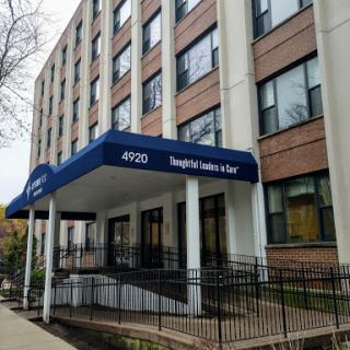 Front view of an office building with a blue awning.
