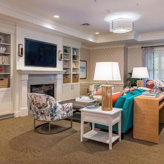 A cozy and well-decorated living room featuring a comfortable sofa, a fireplace, and a mounted television.