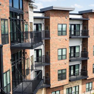 A modern apartment building with brick exterior and balconies.