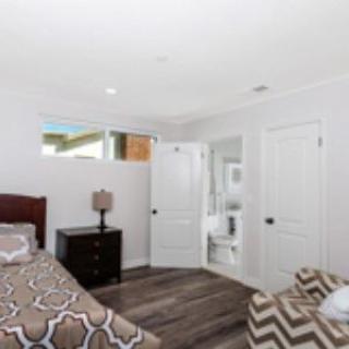 A cozy bedroom with a bed, nightstand, and a view into an adjoining bathroom.