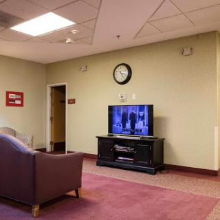 A cozy living room setup featuring a television, a comfortable sofa, and a wall clock.