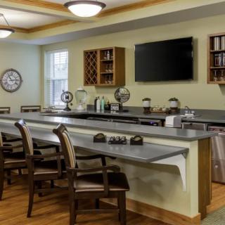 A modern kitchen bar area with seating and a television.