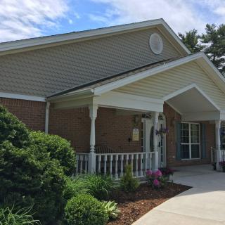 A residential building with a small garden and a porch at the entrance.