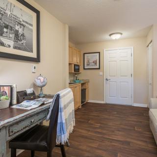 A cozy home office with a desk, chair, and decorative elements.