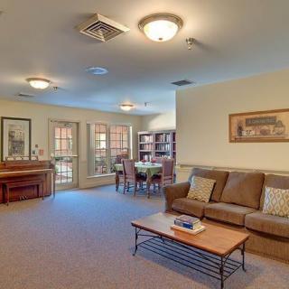 A cozy living room with a sofa, coffee table, and a dining area in the background.