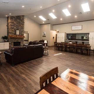 A spacious and modern living room with a fireplace, hardwood floors, and an open dining area.