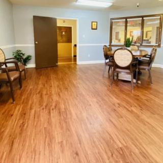 A well-lit dining area with wooden flooring and comfortable seating.