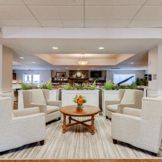A modern lobby with comfortable seating, a central table, and elegant decor.