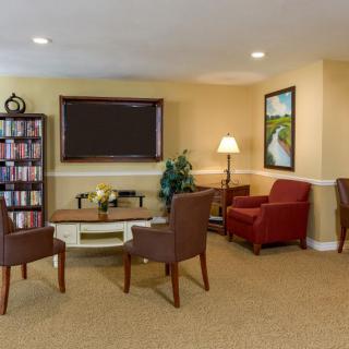 A cozy living room with comfortable seating, a bookshelf, and a television.