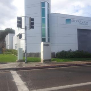 A modern building with a clear blue sky and traffic lights in an urban setting.