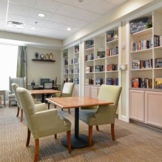A cozy library with bookshelves, tables, and chairs for reading.