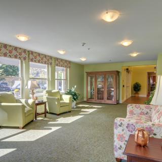 A cozy living room with comfortable seating and ample natural sunlight streaming through large windows.