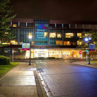 A modern building illuminated at night, showcasing its contemporary design in an urban setting.