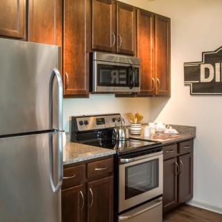 A modern kitchen with stainless steel appliances and dark wood cabinets.
