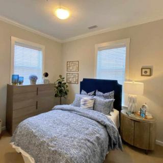 A cozy and well-decorated bedroom with a neatly made bed, stylish nightstand, and tasteful decor.
