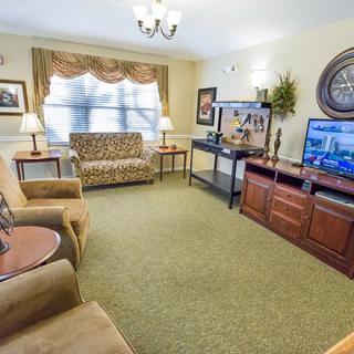 A cozy living room with comfortable seating and two televisions.