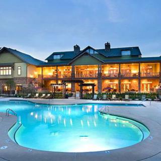 A luxurious resort with a glowing swimming pool at night.