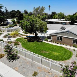 A suburban house with a well-maintained garden and white picket fence.