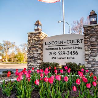 Entrance sign for Lincoln Court Retirement and Assisted Living, surrounded by blooming tulips.