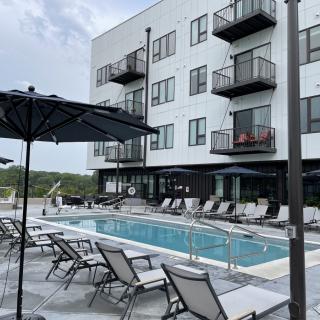 Modern apartment complex with a swimming pool and lounging area.
