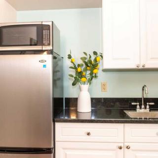 A modern kitchen with stainless steel appliances and a vase of flowers on the counter.