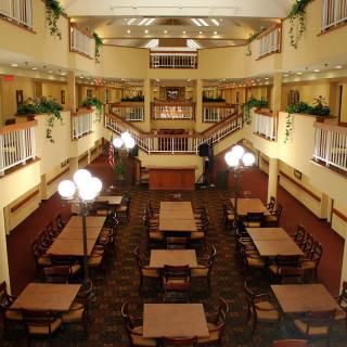 A spacious, elegantly designed dining area in a hotel with multiple tables and ambient lighting.
