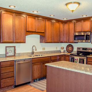 A beautifully designed modern kitchen featuring wooden cabinets, granite countertops, and stainless steel appliances.