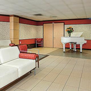 A stylish lobby featuring a white piano and comfortable seating.