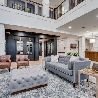 A modern living room with stylish furniture and an open two-story design.
