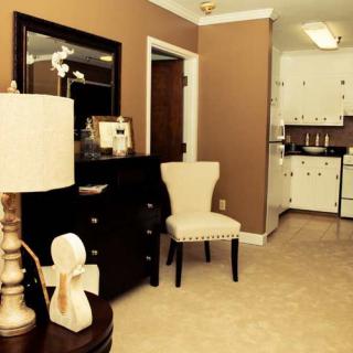 A cozy living area with a view into the kitchen, featuring elegant furniture and warm lighting.