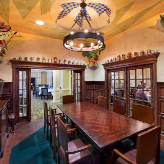 A beautifully designed dining or conference room featuring a large wooden table, traditional decor, and an ornate chandelier.
