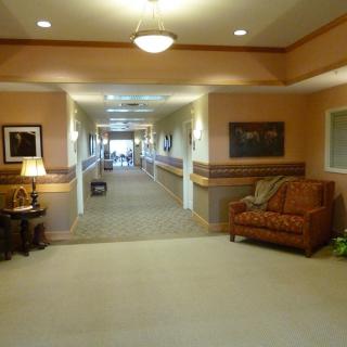 A warmly lit hallway with comfortable seating and decorative artwork.