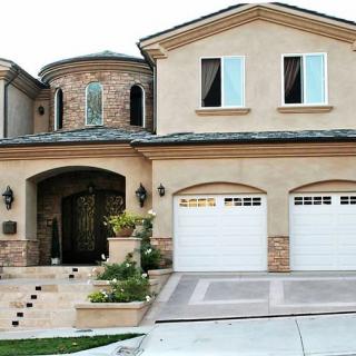 A luxury two-story house with a double garage and elegant entrance.