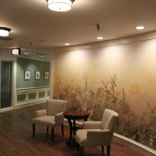 A serene waiting area featuring two chairs and a decorative wall mural.