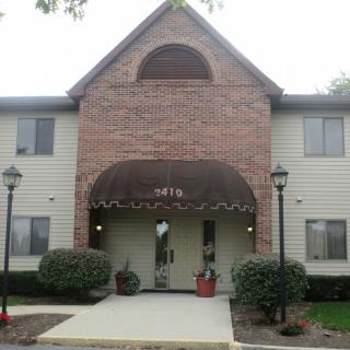 A residential building entrance with brick facade and awning.