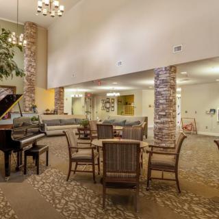 A spacious lobby with a grand piano, comfortable seating, and elegant lighting.