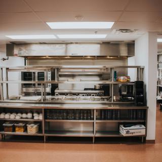 A clean and well-organized commercial kitchen with stainless steel appliances.