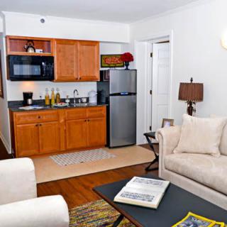 A cozy apartment with a small kitchenette and comfortable living room area.