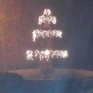 A beautifully lit fountain at night with cascading lights.