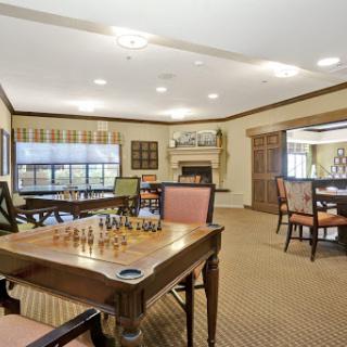 A cozy game room featuring chess tables and comfortable seating, perfect for socializing and enjoying games.
