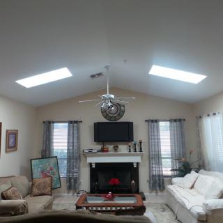 A cozy living room with a fireplace, television, and comfortable sofas.
