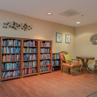 A cozy reading corner featuring a bookshelf filled with colorful books, comfortable seating, and decorative elements.