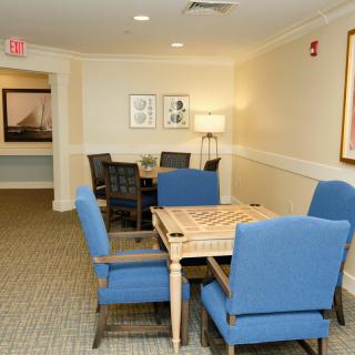 A cozy indoor game room with a board game table and plush blue chairs.