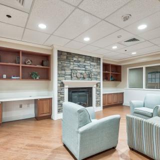 A modern living room with comfortable seating and a stone fireplace.