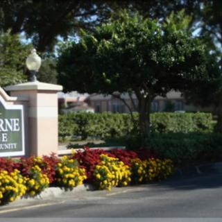 Entrance sign surrounded by flowers at a golf course community.