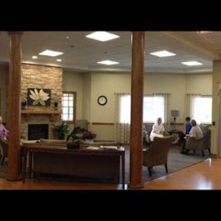 A cozy lounge area with comfortable seating, natural light, and people engaged in conversation.
