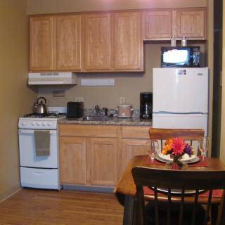 Compact kitchen with wooden cabinets and dining area.
